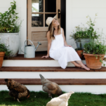 Photo of Chloe Mackintosh Founder of Boxwood Avenue outside in a white sundress on ranch.
